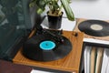 Stylish turntable with vinyl disc on table in room, closeup Royalty Free Stock Photo