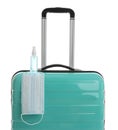 Turquoise suitcase, antiseptic spray and protective mask on white background. Travelling during coronavirus pandemic