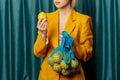 Stylish ukrainian woman in yellow sunglasses and jacket with lemons in net bag Royalty Free Stock Photo