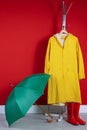 Stylish umbrella, raincoat and boots near wall Royalty Free Stock Photo