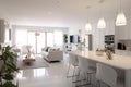 Stylish and upscale interior design merging a white kitchen, dining, and living area Royalty Free Stock Photo