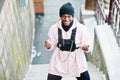 Stylish urban style african american man in pink hoodie posed at winter day and boxing hands