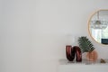 Stylish vertical composition of red mirror table lamp with gold stationary on white marble top with copy space on white wall