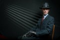 Stylish vintage detective posing on a chair Royalty Free Stock Photo