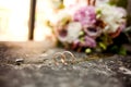 Stylish wedding bouquet flowers from bush roses, eustoma and gold wedding rings on the stone on the background nature. Wedding cer Royalty Free Stock Photo