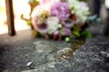 Stylish wedding bouquet flowers from bush roses, eustoma and gold wedding rings on the stone on the background nature. Wedding cer Royalty Free Stock Photo