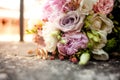 Stylish wedding bouquet flowers from bush roses, eustoma and gold wedding rings on the stone on the background nature. Wedding cer Royalty Free Stock Photo