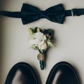 Stylish wedding bow tie with modern flowers bouquet and shoes on wooden background top view. rustic wedding morning preparation.