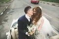 Stylish wedding couple, bride, groom kissing and hugging on retro car Royalty Free Stock Photo