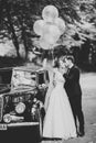 Stylish wedding couple, bride, groom kissing and hugging on retro car Royalty Free Stock Photo