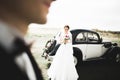 Stylish wedding couple, bride, groom kissing and hugging on retro car Royalty Free Stock Photo