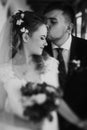 stylish wedding couple hugging and posing. luxury bride and groom embracing. tender sensual moment. romantic black white photo