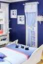 Stylish white-blue children room with original bed