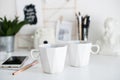 Stylish white desktop, home office interior details with two cof