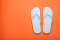 Stylish white flip flops on orange background, top view. Space for text Royalty Free Stock Photo