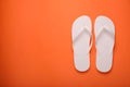 Stylish white flip flops on orange background, top view. Space for text Royalty Free Stock Photo