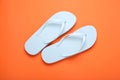 Stylish white flip flops on orange background, top view Royalty Free Stock Photo