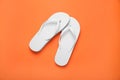 Stylish white flip flops on orange background, top view Royalty Free Stock Photo