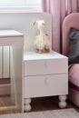 Charming and Elegant White Nightstand Perfectly Complemented by a Decorative Toy for Kids