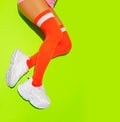 Stylish white Sneakers and vintage orange stockings on yellow fresh minimal background. Sport fitness summer active vibes