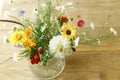 Stylish wildflowers bouquet in sunlight on rustic wooden table. Beautiful summer flowers in vase gathered from garden, floral Royalty Free Stock Photo