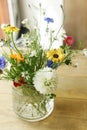 Stylish wildflowers bouquet in sunlight on rustic wooden table. Beautiful summer flowers in vase gathered from garden, floral Royalty Free Stock Photo
