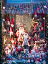 Stylish window store with christmas toys at holiday market in city street. Christmas street decor.