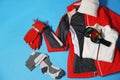 Stylish winter sport clothes on light blue background, flat lay