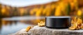 Stylish wireless earbuds placed on rounded rocks beside a tranquil river, with lush greenery and mountains in the backdrop Royalty Free Stock Photo