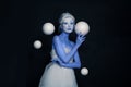 Stylish woman actress with stage makeup and hairstyle standing with white spheres on black banner background Royalty Free Stock Photo