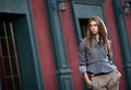 Stylish woman against old building wall