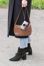 Stylish woman in black coat walking with retro point and shoot 35mm film camera during late 90's and early Royalty Free Stock Photo