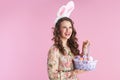 Stylish woman with bunny ears and basket of easter eggs Royalty Free Stock Photo