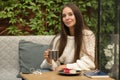 Stylish woman in a cafe with a cup of coffee and cheesecake. Business lunch