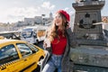 Stylish woman with cup of tea dreamy looking away in warm october day. Attractive white girl in beret posing with