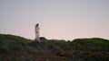 Stylish woman exploring landscape alone. Blonde girl walking at sunset nature