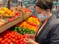 Stylish woman grocery shopping in a face mask Royalty Free Stock Photo