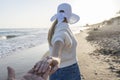 Stylish woman holding man hand walking and traveling together on the beach at sunset.Follow me , summer lifestyle vacations Royalty Free Stock Photo