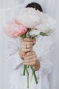 Stylish woman holding peony bouquet in hands. Young female hiding behind peony flowers. Wedding Royalty Free Stock Photo