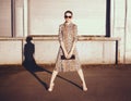 Stylish woman in a leopard dress, glasses and bag in the ghetto