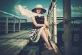 Stylish woman on old wooden pier