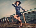 Stylish woman on old wooden pier