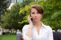 Stylish woman in the park talking on mobile phone