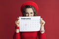 stylish woman in red dress and beret with February calendar