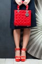 Stylish woman`s outfit. Beautiful woman wearing platform sandals shoes holding red trendy handbag