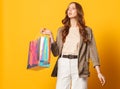 Stylish woman with shoping bag isolated on yellow background