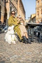 Woman sitting with her white dog at outdoor cafe in the old town of Bologna city Royalty Free Stock Photo