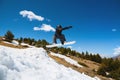 Stylish woman snowboarder makes a trick in flight. Snowboard jump from a kicker against the backdrop of mountains Royalty Free Stock Photo