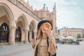 Stylish woman tourist holding prezel, traditional polish snack on the Market square in Krakow. Tourist hand holding