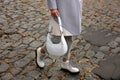 Stylish woman with trendy white baguette bag on city street, closeup Royalty Free Stock Photo